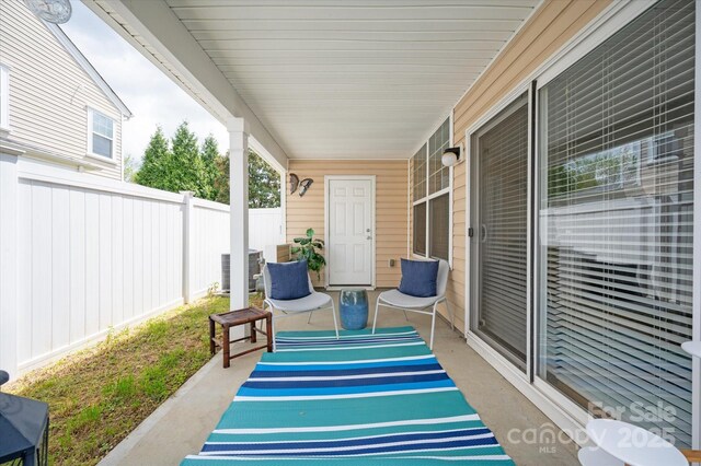 view of patio / terrace featuring a porch and fence