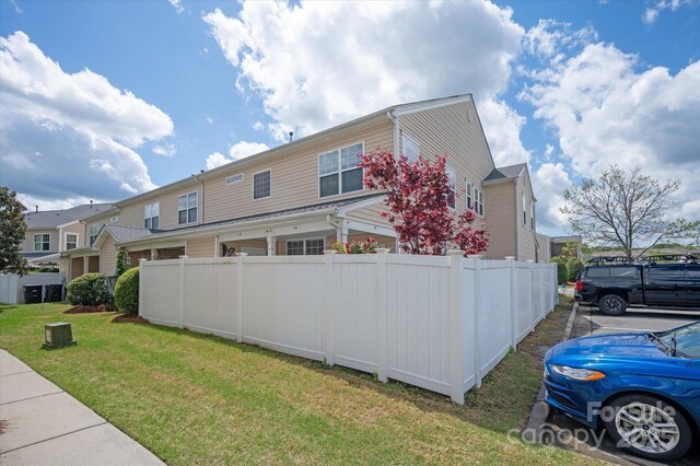 view of property exterior featuring fence and a yard