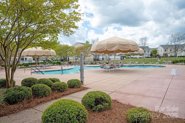 community pool featuring fence and a patio