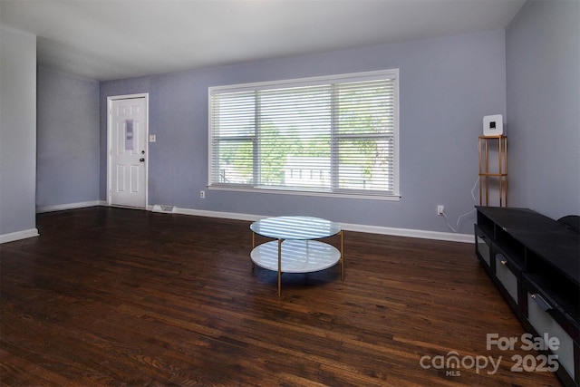 living area with visible vents, baseboards, and wood finished floors