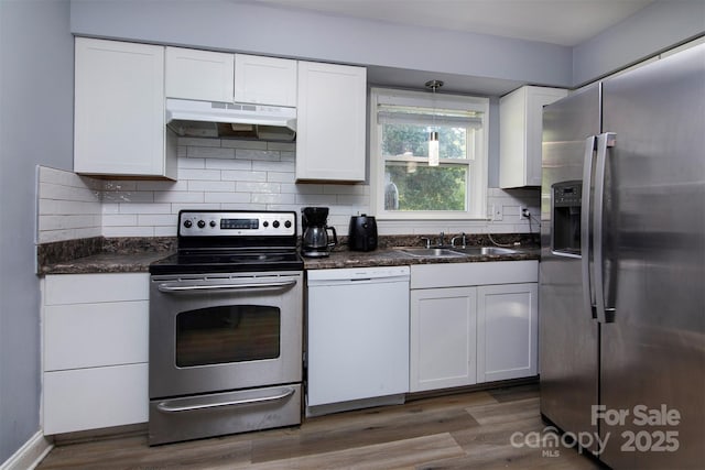 kitchen with appliances with stainless steel finishes, a sink, white cabinets, and under cabinet range hood
