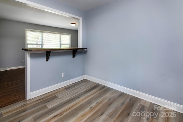 empty room with wood finished floors and baseboards