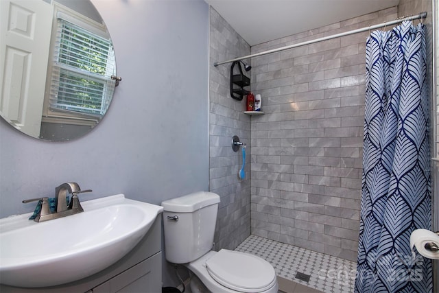 full bath with toilet, tiled shower, and vanity