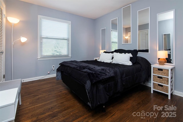 bedroom with baseboards and dark wood finished floors