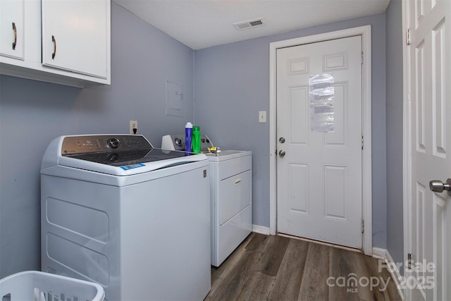 washroom featuring cabinet space, baseboards, washing machine and dryer, and dark wood-style floors