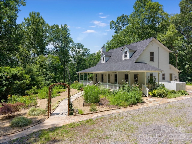 109 Paradise Cir, Clyde, NC 28721 - view of front facade with covered porch, a chimney, a shingled roof, and view of scattered trees