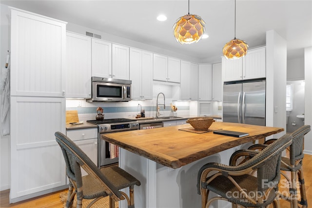 109 Paradise Cir, Clyde, NC 28721 - kitchen featuring stainless steel appliances, wooden counters, light wood-style flooring, a breakfast bar, and a center island
