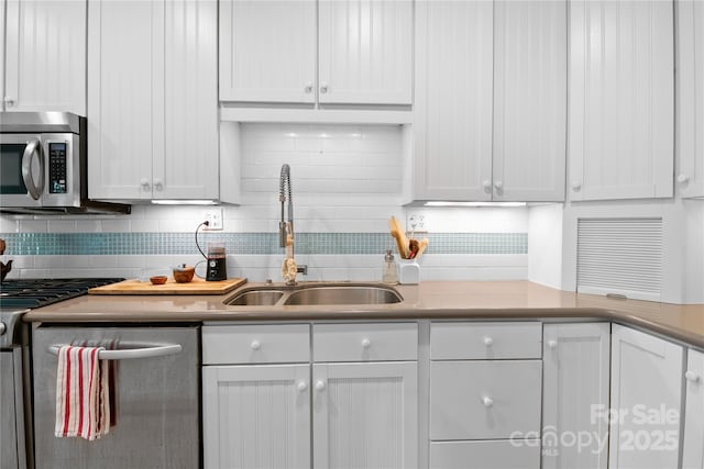 109 Paradise Cir, Clyde, NC 28721 - kitchen with stainless steel appliances, white cabinetry, backsplash, and light countertops