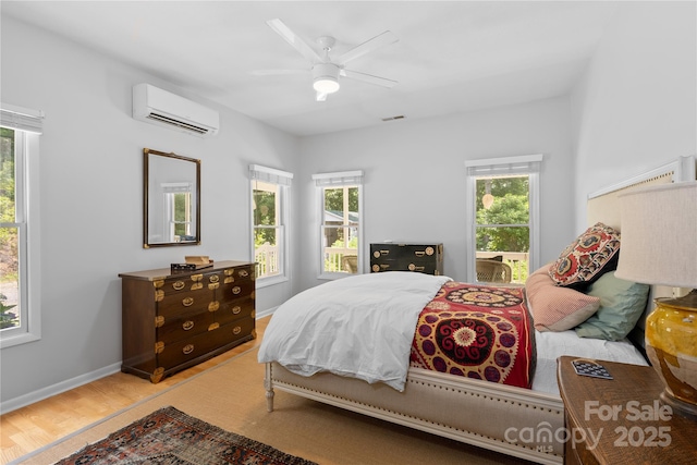 109 Paradise Cir, Clyde, NC 28721 - bedroom featuring a wall mounted air conditioner, light wood-style flooring, and a ceiling fan