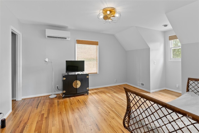 109 Paradise Cir, Clyde, NC 28721 - unfurnished bedroom with a wall mounted AC, wood finished floors, and lofted ceiling