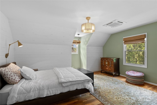 109 Paradise Cir, Clyde, NC 28721 - bedroom featuring multiple windows, vaulted ceiling, and wood finished floors