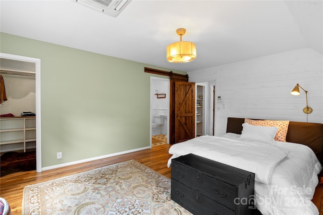109 Paradise Cir, Clyde, NC 28721 - bedroom with a barn door, wood finished floors, a spacious closet, and a closet