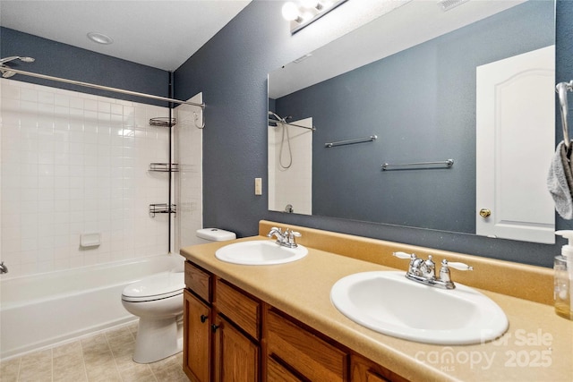 bathroom with a sink, bathing tub / shower combination, toilet, and double vanity