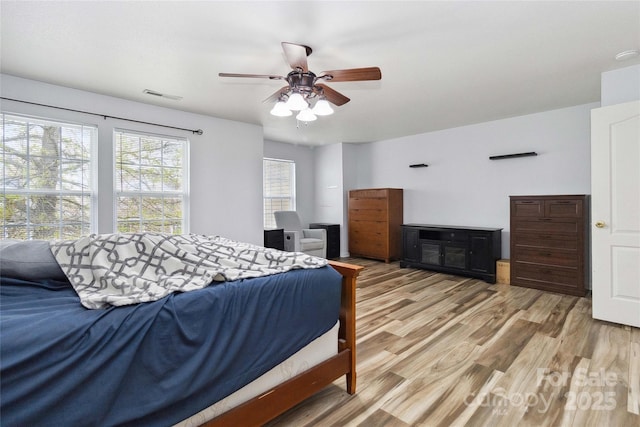 bedroom featuring visible vents, a ceiling fan, and wood finished floors