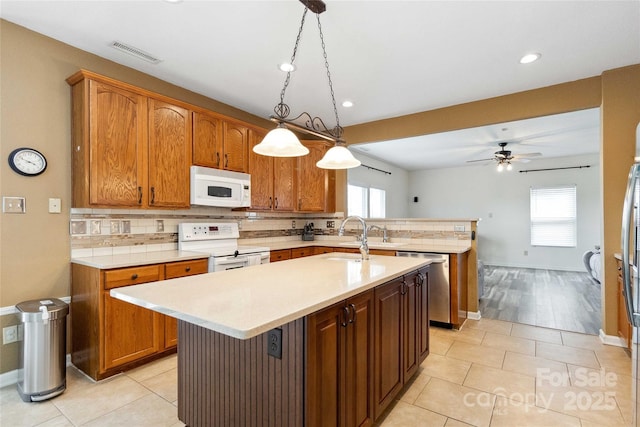 kitchen featuring white appliances, decorative backsplash, a sink, and light countertops