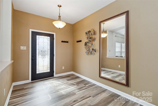 entryway featuring baseboards and wood finished floors