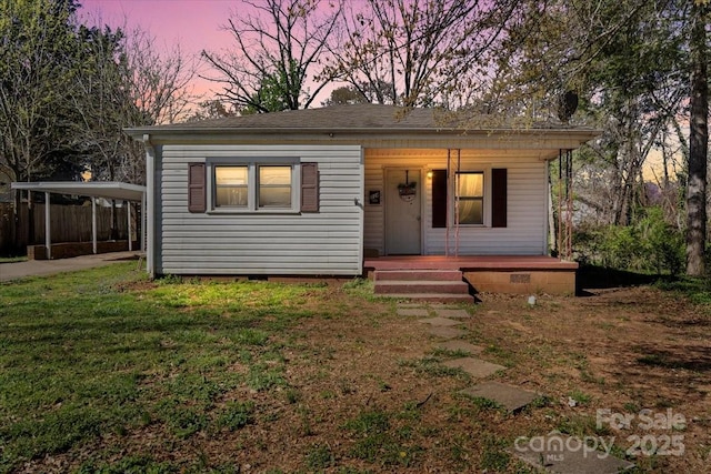 bungalow-style house with driveway, a lawn, a carport, crawl space, and a porch