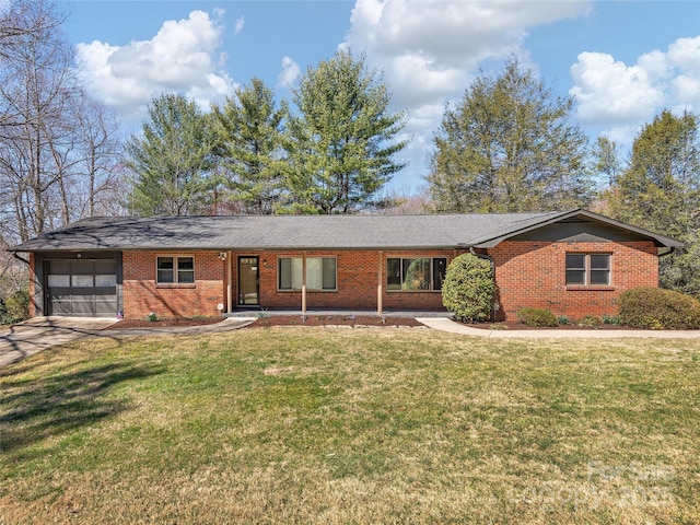 single story home with a front yard, an attached garage, brick siding, and concrete driveway