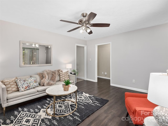 living area featuring baseboards, ceiling fan, and wood finished floors