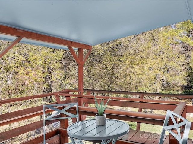 wooden terrace featuring a forest view