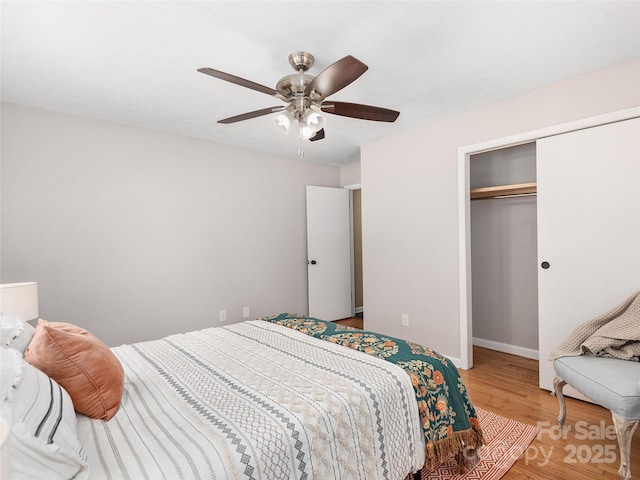bedroom featuring a closet, baseboards, ceiling fan, and wood finished floors