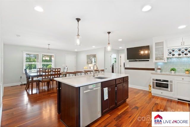 kitchen featuring stainless steel appliances, light countertops, a sink, and recessed lighting