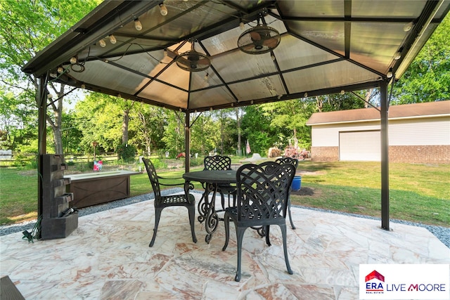 view of patio featuring a gazebo, an outbuilding, and outdoor dining area
