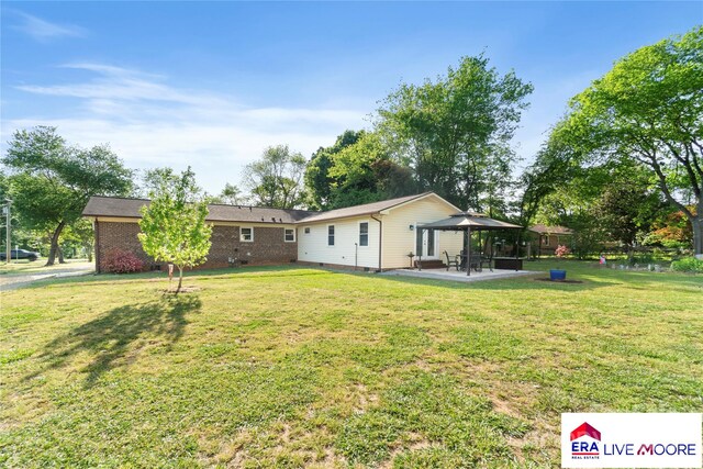 rear view of property with a lawn, a gazebo, a patio, and crawl space