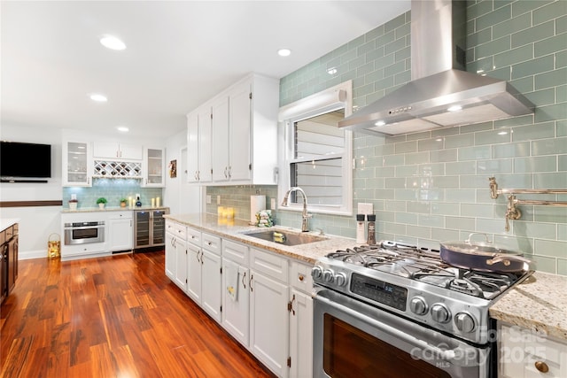 552 Odell School Rd, Concord, NC 28027 - kitchen featuring stainless steel appliances, wall chimney range hood, a sink, tasteful backsplash, and white cabinetry
