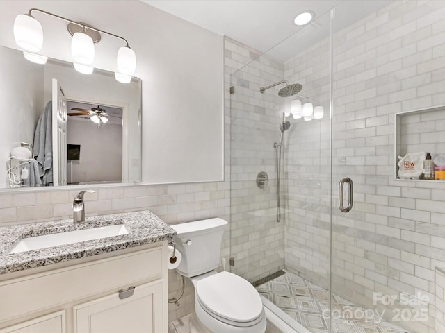 2214 Olde Chantilly Ct, Charlotte, NC 28205 - full bathroom with a ceiling fan, a shower stall, tile walls, vanity, and toilet