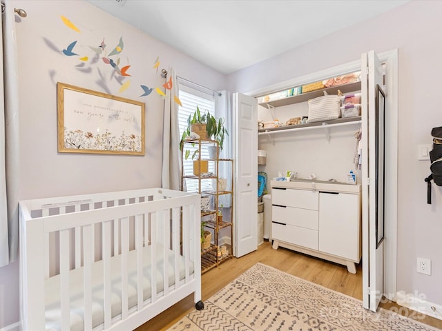 2214 Olde Chantilly Ct, Charlotte, NC 28205 - bedroom with light wood-style flooring, a nursery area, and a closet