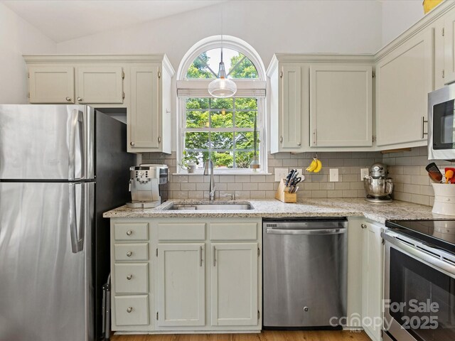 2214 Olde Chantilly Ct, Charlotte, NC 28205 - kitchen with appliances with stainless steel finishes, a sink, decorative backsplash, light stone countertops, and vaulted ceiling
