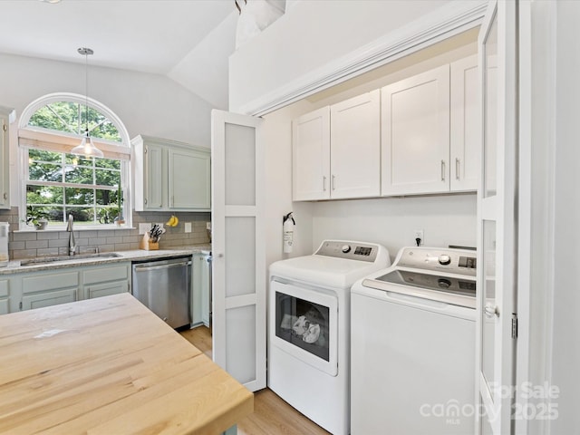 2214 Olde Chantilly Ct, Charlotte, NC 28205 - laundry room with separate washer and dryer, light wood finished floors, and cabinet space