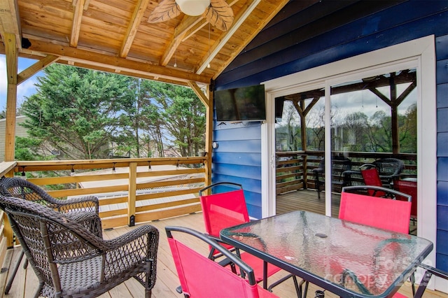 wooden deck featuring outdoor dining space and a ceiling fan