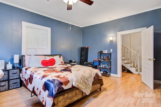 bedroom featuring light wood-style floors, ceiling fan, crown molding, and baseboards