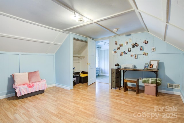 bonus room with wood finished floors, baseboards, lofted ceiling, and visible vents
