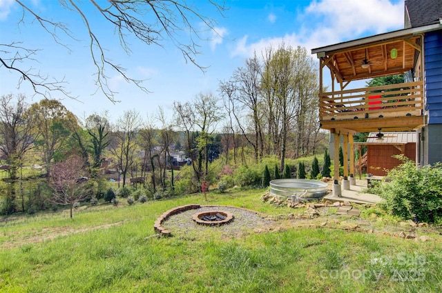 view of yard with a ceiling fan and a fire pit