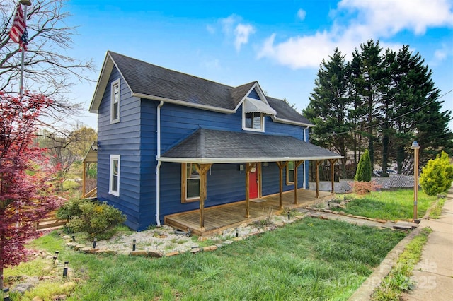 view of front of property with a front yard, a porch, and a shingled roof
