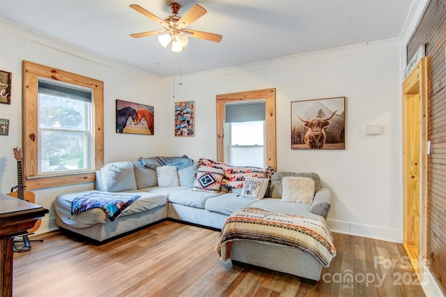 living area featuring wood-type flooring, crown molding, and ceiling fan