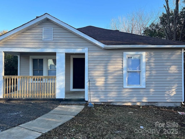 view of front of house with a shingled roof and a porch