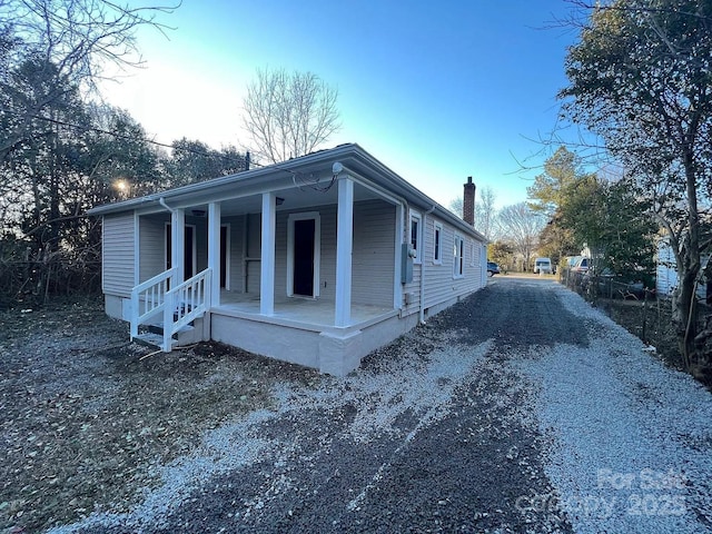 view of front of house featuring a porch and a chimney
