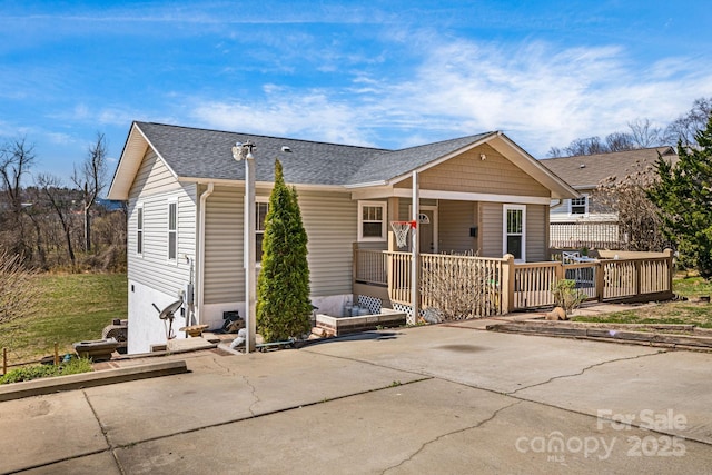 view of front of home with covered porch and a shingled roof