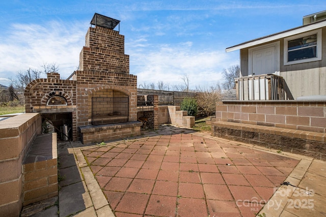 view of patio with an outdoor brick fireplace