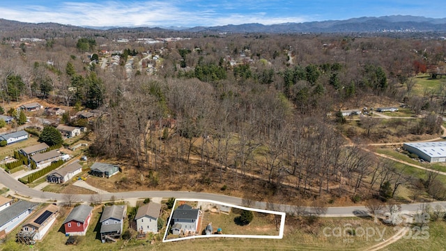 aerial view featuring a wooded view, a mountain view, and a residential view