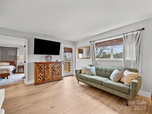 living area featuring light wood-style flooring and baseboards