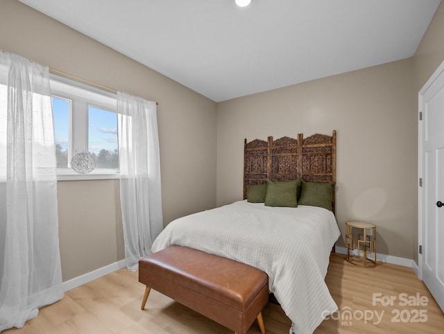 bedroom with baseboards and light wood-type flooring