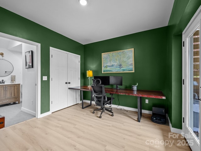 office area with baseboards and wood finished floors
