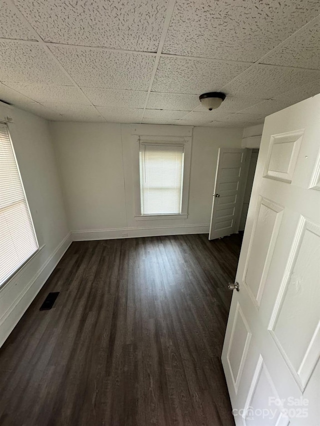 4510 Wildwood Ave, Charlotte, NC 28208 - empty room with dark wood-style floors, baseboards, and a paneled ceiling