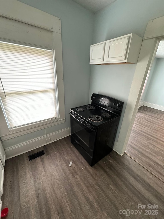 4510 Wildwood Ave, Charlotte, NC 28208 - kitchen with white cabinetry, dark wood-type flooring, baseboards, black range with electric cooktop, and visible vents