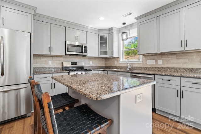 10270 Lakeshore Dr, Lancaster, SC 29720 - kitchen with light stone countertops, appliances with stainless steel finishes, a sink, light wood finished floors, and a breakfast bar area